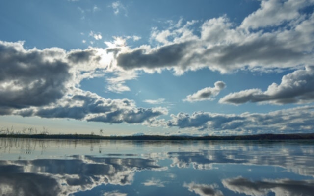 Picture of a lake with clouds overhead.